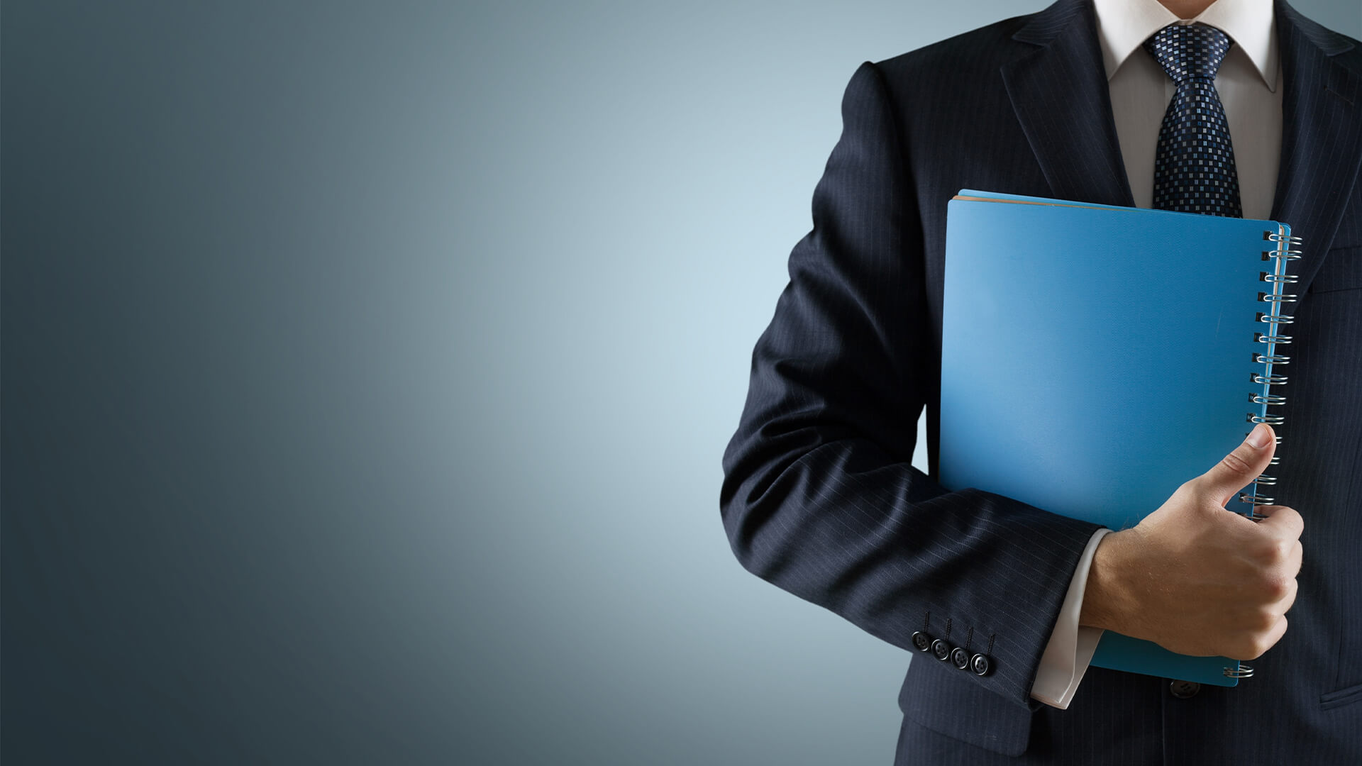 Man in a business suit with a blue notebook against a blue background